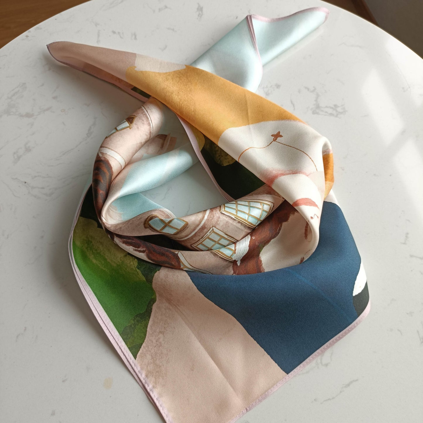 This bookish silk scarf features an elegant illustration of Pride and Prejudice's main characters, Mr. Darcy and Elizabeth Bennet. Made from high-quality silk, it has a luxurious texture and a lovely sheen.
